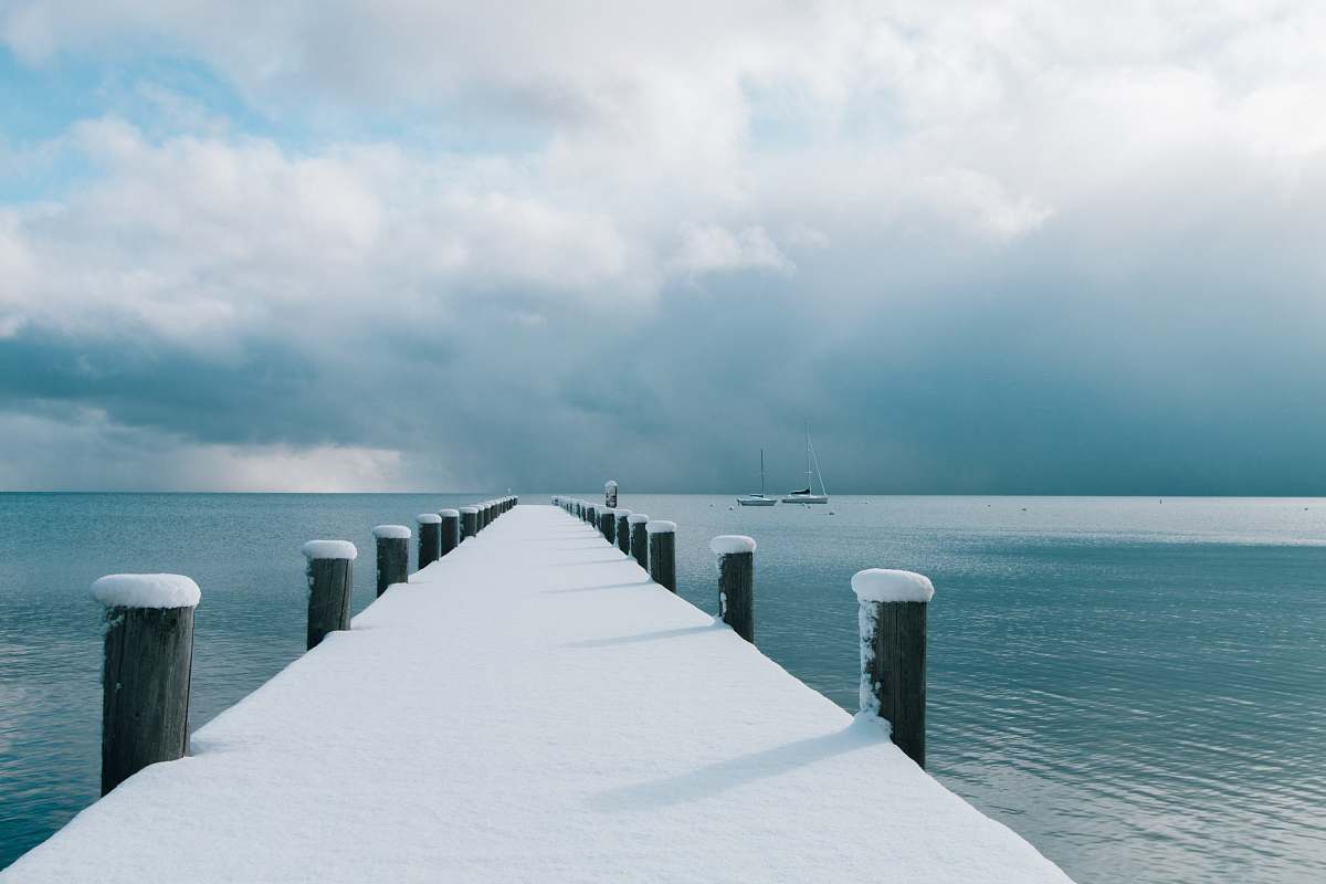 lake tahoe brown wooden dock covered with snow and body of water snow
